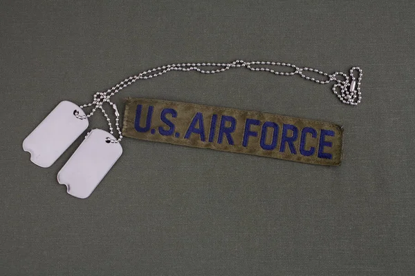 オリーブ グリーンの一様な背景に犬のタグを持つ米国の空軍支店テープ — ストック写真