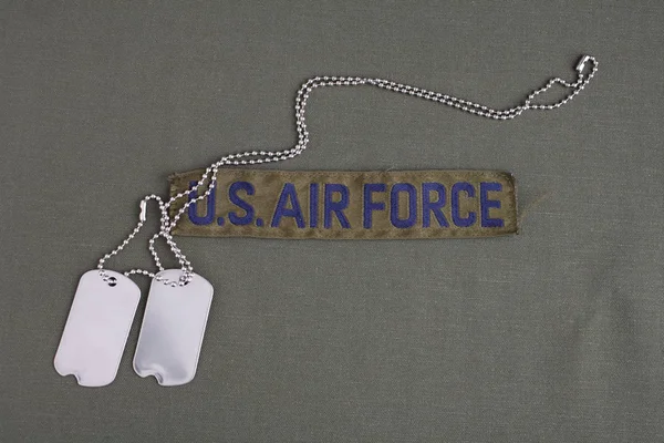 オリーブ グリーンの一様な背景に犬のタグを持つ米国の空軍支店テープ — ストック写真