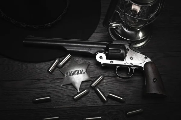 Old western cold blast lantern, marshals badge and revolver with cartridges — Stock Photo, Image