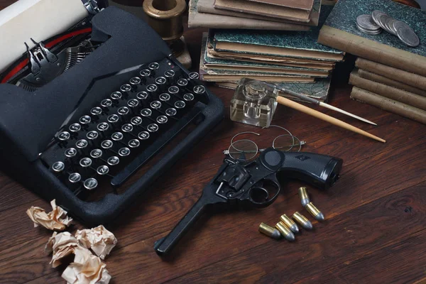 Escribir una historia de ficción criminal - vieja máquina de escribir retro vintage y pistola de revólver con municiones, libros, papeles, pluma de tinta vieja —  Fotos de Stock