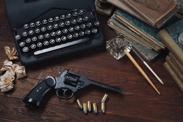 Написание криминальной истории - старинная ретро-винтажная пишущая машинка и револьвер с боеприпасами, книгами, бумагами, старой чернильной ручкой — стоковое фото