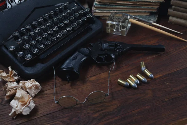 Escribir una historia de ficción criminal - vieja máquina de escribir retro vintage y pistola de revólver con municiones, libros, papeles, pluma de tinta vieja —  Fotos de Stock