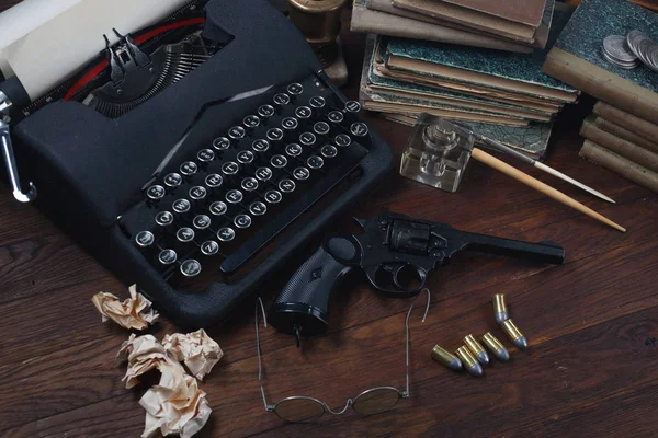 Escribir una historia de ficción criminal - vieja máquina de escribir retro vintage y pistola de revólver con municiones, libros, papeles, pluma de tinta vieja —  Fotos de Stock