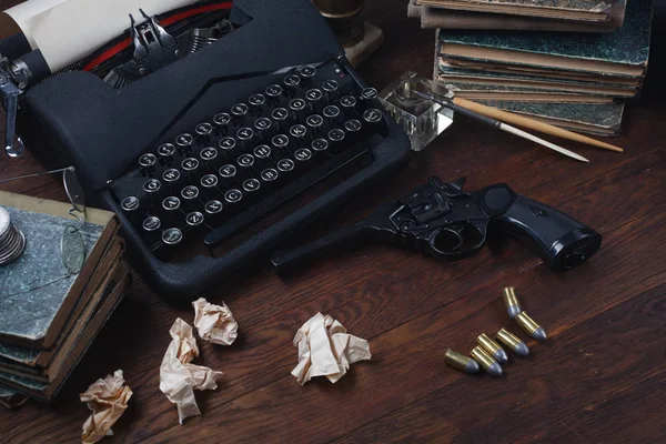 Schrijven van een misdaad fictie verhaal - oude retro vintage typemachine en revolver geweer met munitie, boeken, papers, oude inkt pen — Stockfoto
