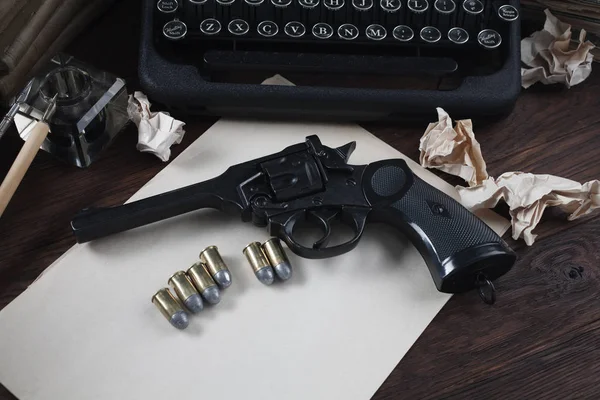 Escribir una historia de ficción criminal: vieja máquina de escribir retro vintage y pistola de revólver con municiones, libros, papel en blanco, pluma de tinta vieja — Foto de Stock