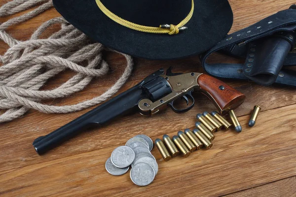 Stock image Wild West background - .44 smith and wesson single action revolver gun with cartridges and black hat with silver dollar coins