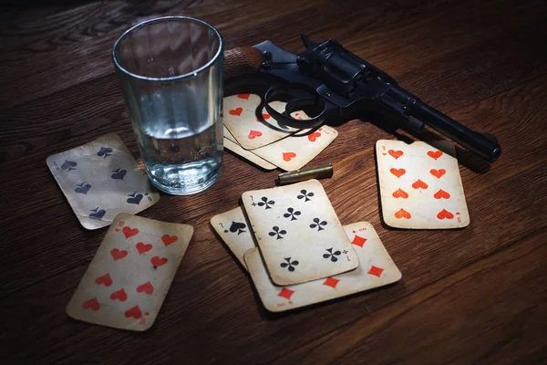Ruleta rusa - tarjeta de trenzado, vaso de vodka y revólver con un cartucho en tambor — Foto de Stock