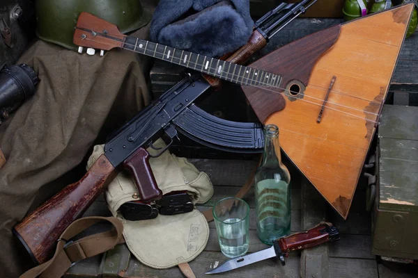 Kalachnikov AK 47 avec des munitions, vodka et balalaika sur fond de boîte de l'armée — Photo