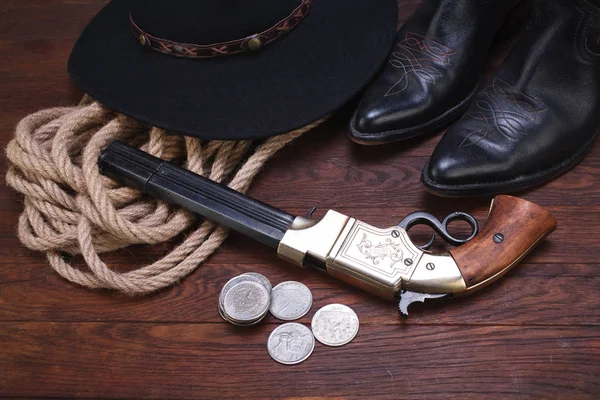 Antiguo cañón occidental con dólares de plata con sombrero, cuerda y botas — Foto de Stock
