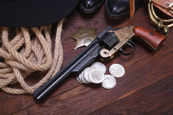 Vieux canon occidental avec badge de maréchal et dollars argentés avec chapeau, corde et bottes — Photo