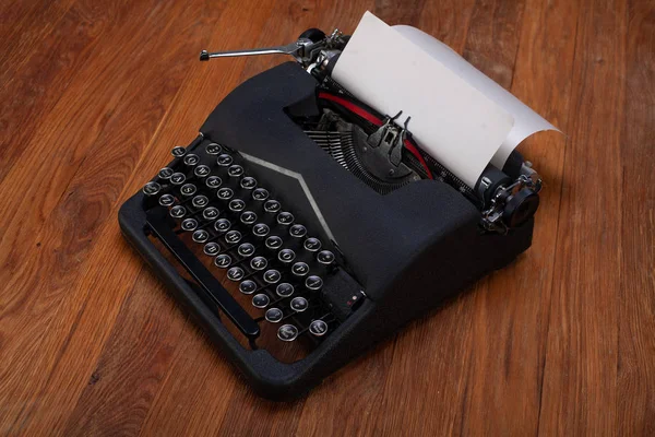 Máquina de escrever vintage retro velho com papel na placa de madeira — Fotografia de Stock
