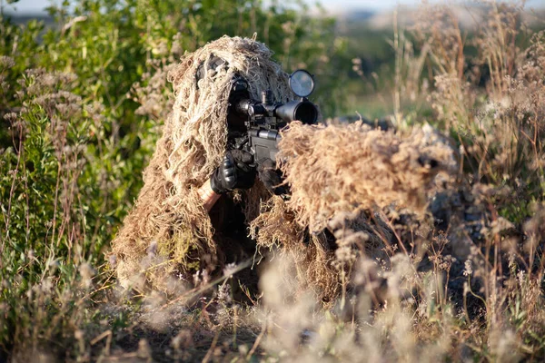 山の戦闘位置を視える高精度ライフルでギリースーツの狙撃手 — ストック写真