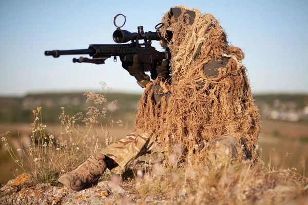 山の戦闘位置を視える高精度ライフルでギリースーツの狙撃手 — ストック写真