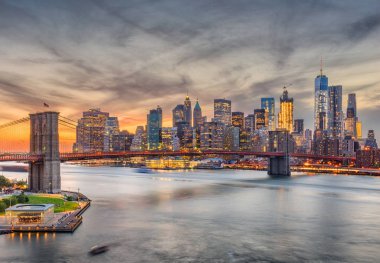 Manhattan'ın Doğu Nehri ile Brooklyn Köprüsü güneş battıktan sonra New York, New York, ABD skyline.