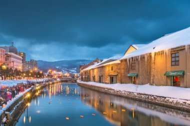Otaru, Japonya kış manzarası ışık saçtığını alacakaranlık sırasında kanallar üzerinde.