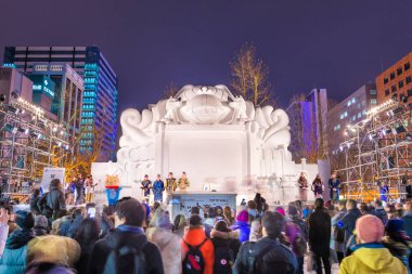 Sapporo, Japonya - 5 Şubat 2017: Sapporo kar Festivali açılışı geleneksel Aynu gardıropta giyinmiş performans sunmak. Olay başlar 1950 yılında.