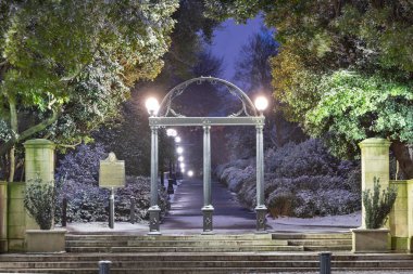 ATİNA, GEORGIA - 17 HAZİRAN 2018 Gürcistan Üniversitesi kampüs kemeri kışın alacakaranlıkta tarihi eyalet işaretiyle.