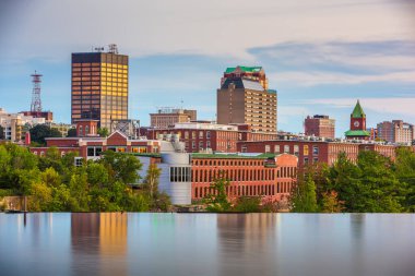 Manchester, New Hampshire, USA Skyline Merrimack Nehri üzerinde alacakaranlıkta.
