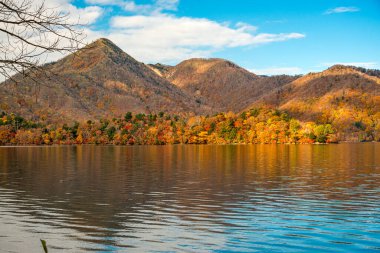 Nikko, Japonya 'daki Chuzenji Gölü etrafındaki dağlara yapraklar dökülüyor..