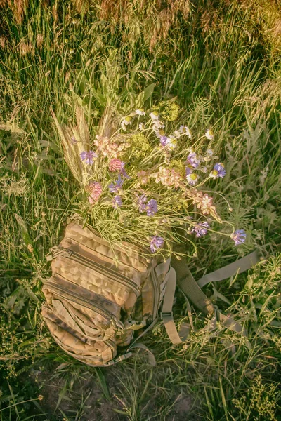 Ein Strauß Wilder Blumen Einem Militärrucksack Auf Einem Weizenfeld Wird — Stockfoto