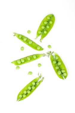 Beyaz arkaplanda kabuklu yeşil bezelyeler