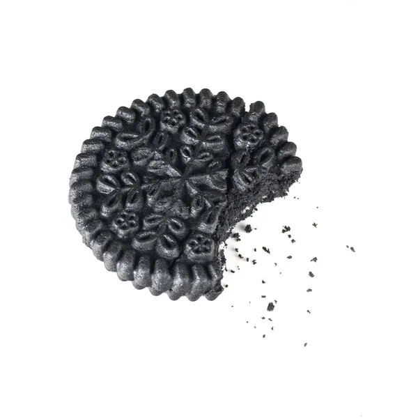 Black round biscuit biting with crumbs, isolated closeup — Stock Photo, Image