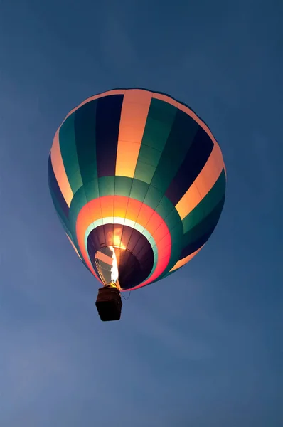 Ein Ballon fliegt in den Nachthimmel, eine Feuerflamme bläst eine — Stockfoto