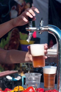 barmen plastik bir bardak içine bira dökülen