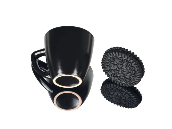 Taza negra y galletas redondas negras con reflejo, aisladas — Foto de Stock