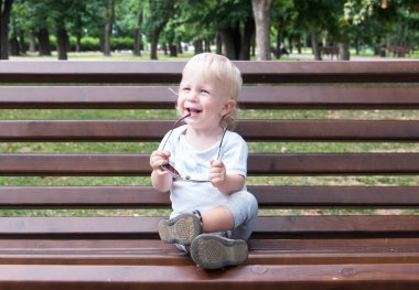 güneş gözlüğü ile oturan çocuk, bir wo mavi gözlü blondidan