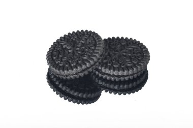 Beyaz arka planda iki yuvarlak siyah kurabiye var.