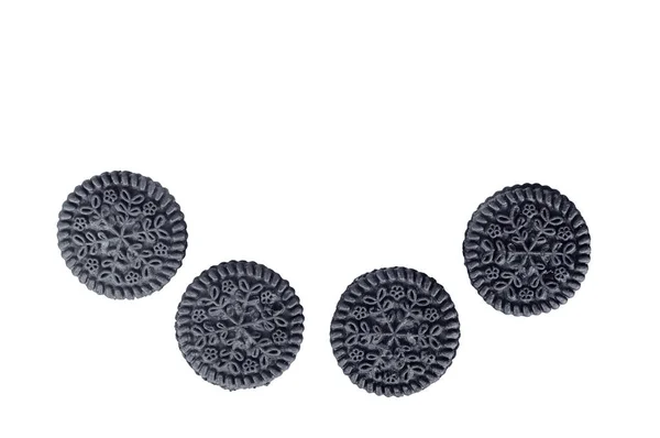 Four round black cookies on a white background isolated — Stock Photo, Image