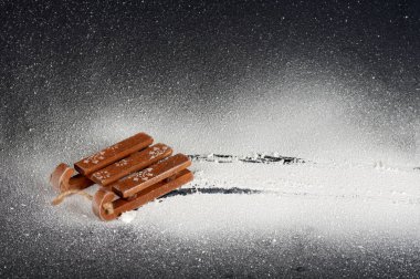 Beyaz yapay kar üzerinde ahşap kızak, kızak izi, siyah sırt.