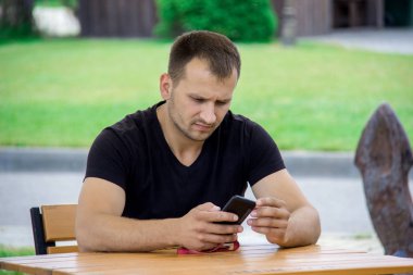 Adam ciddi ifade ile kafede çıkıyor smartphone ile.