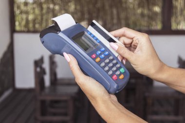 Banka terminal için kredi kartıyla ödeme kullanan kadın.