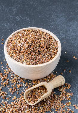 Ahşap kase ve metniniz için kopya alanı bir granit taş zemin üzerine keten tohumu ile kepçe.