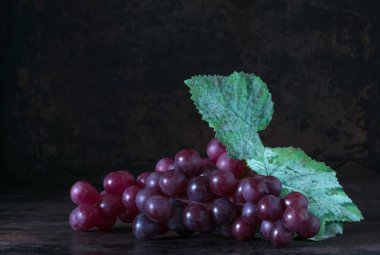 Kopya alanı metniniz için rustik bir zemin üzerine kırmızı üzüm demet