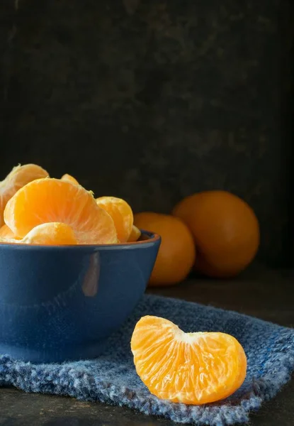 Een Blauwe Kom Oranje Tangerine Segmenten Tegen Een Donkere Rustieke — Stockfoto