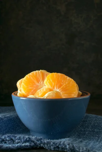 Een Blauwe Kom Oranje Tangerine Segmenten Tegen Een Donkere Rustieke — Stockfoto