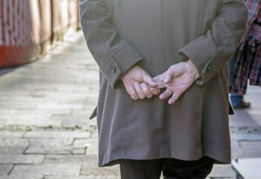 Niedersachsen, Almanya 28 Kasım 2015: sokak boyunca yürürken yaşlı bir kişi elleri arkada tutuluyor