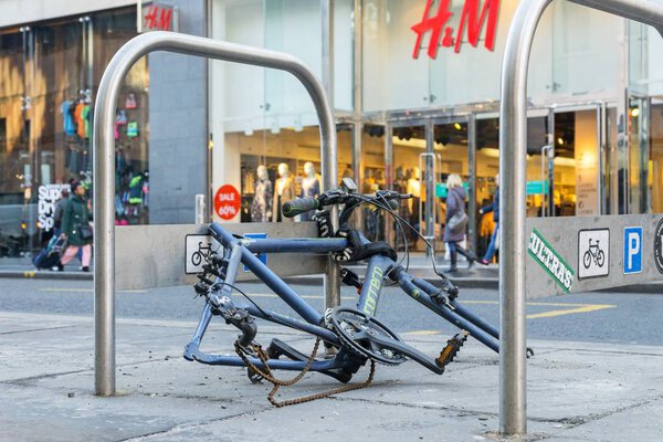 GlasgoW, UNITED KINGDOM JANUARY 23, 2019: Bicycle crime concept with a chained up bicycle in a city center that has been stripped of parts
