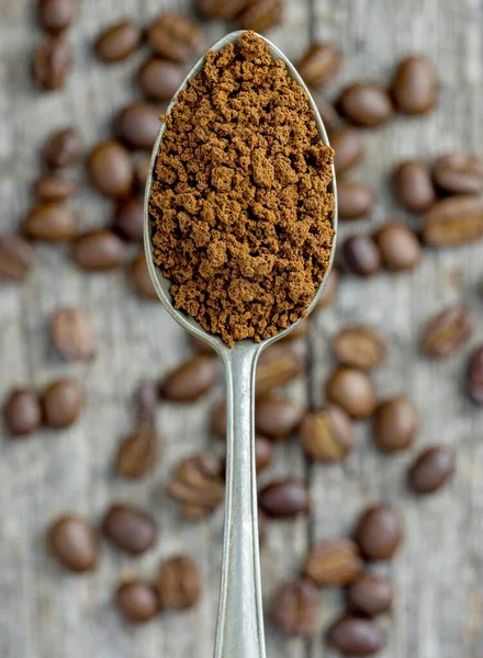 Eine Nahaufnahme Von Einem Löffel Instant Kaffeepulvergranulat Über Kaffeebohnen — Stockfoto