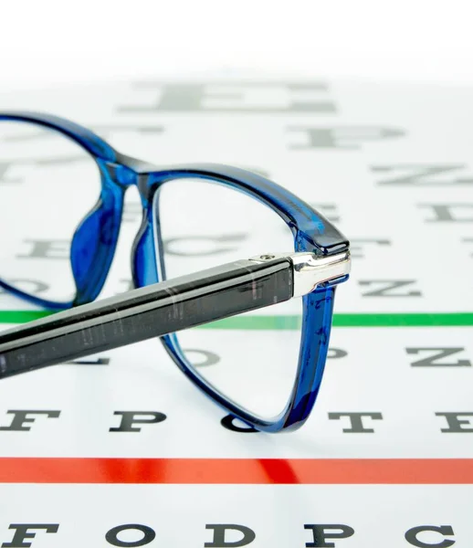 Göz Testi Çizelgesinde Duran Bir Çift Gözlüğün Yakın Çekimi — Stok fotoğraf