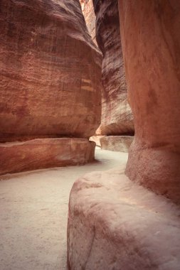 Siq, Petra Arkeoloji Parkı, Ürdün. Dağın doğal olarak bölünmesinden kaynaklanan bu dar vadi ziyaretçileri Petra 'ya götürüyor..