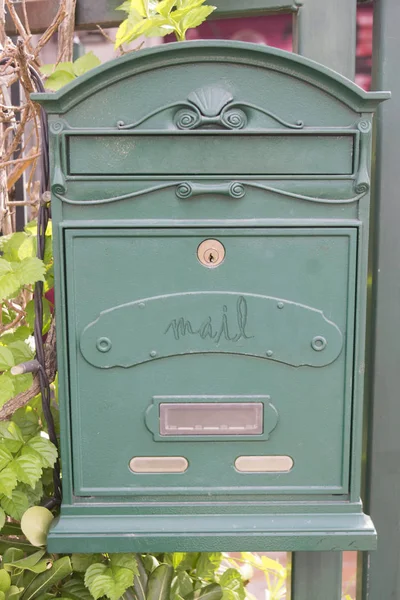 detail of a green mailbox of a house with garden