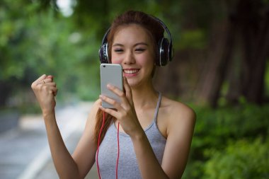 Rahatlatıcı ve kulaklık ile müzik dinleme sırasında şarkı genç kadın. Asyalı kız kulaklık kullanarak duygu kavramı relax. Müzik keyfi mutlu güzel moda kadın modeli.