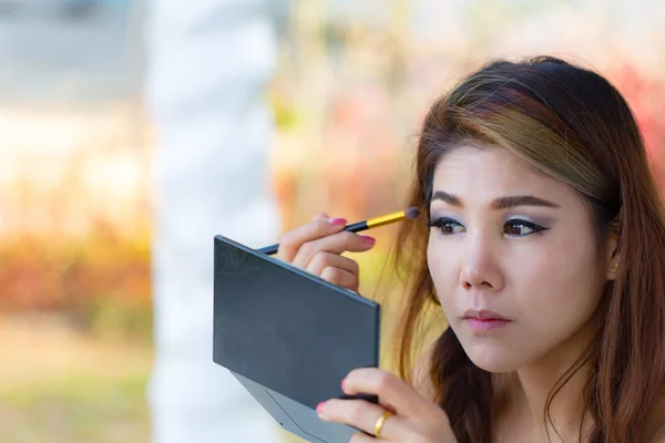 Woman make up on beautiful face. Young Asian girl applying makeup eyeliner on face. beauty fashion concept.