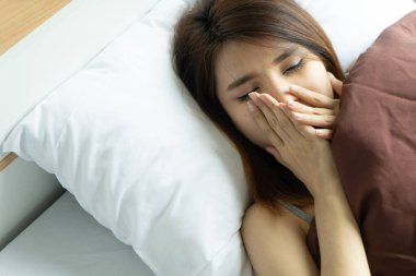 Genç kadın esneme uyanış çalar saat tutarak yorgun. sabah erken uyanmak. Kız Dur erteleme alarm. Erkek uyanmak uykulu ve yorgun. kadın uyan sabah çalar saat erteleme kavramı ile.