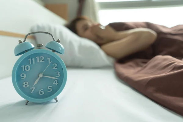 Genç kadın esneme uyanış çalar saat tutarak yorgun. sabah erken uyanmak. Kız Dur erteleme alarm. Erkek uyanmak uykulu ve yorgun. kadın uyan sabah çalar saat erteleme kavramı ile.