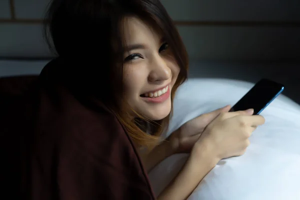 Młoda Kobieta Szczęśliwa Przy Użyciu Telefonu Komórkowego Wiadomość Tekstową Łóżku — Zdjęcie stockowe